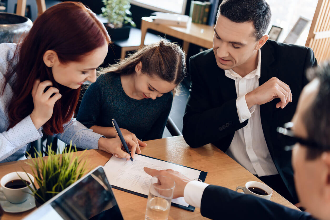New Jersey Lawyer shows mother where to sign Durable Power of Attorney documents while small daughter and husband are sitting beside
